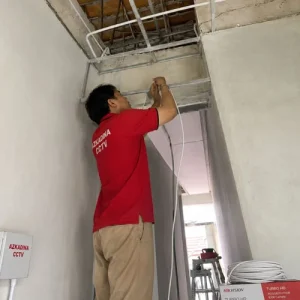 Teknisi Azkadina CCTV memasang kamera CCTV 5 titik pada area carport dan teras rumah di Tangerang dengan penataan kabel rapi.
